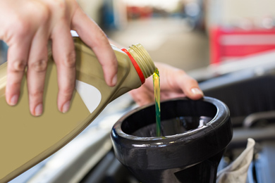 Fresh engine oil being poured into a vehicle